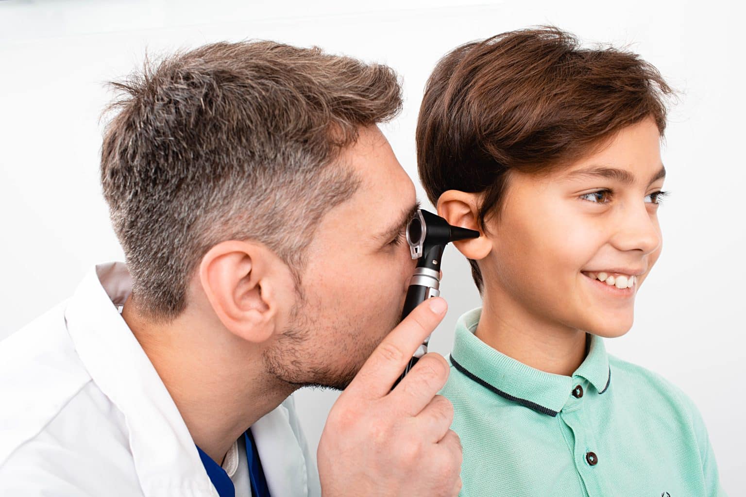 Pediatric-Hearing-Loss-exam Doctor looking inside of a child's ear using a medical instrument